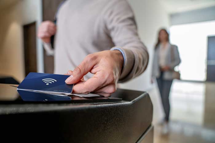Close-up on a business man leaving an office building using an ID card