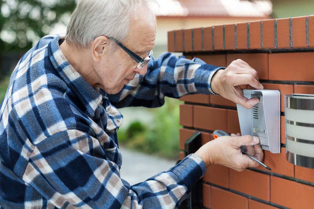 worker installing electric metal mesh fence